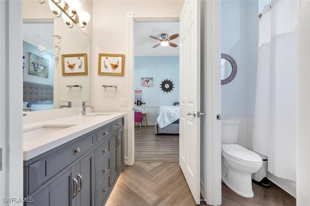 bathroom featuring parquet flooring, vanity, toilet, and ceiling fan