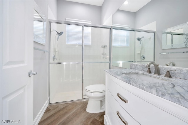 bathroom featuring vanity, a shower with shower door, and toilet