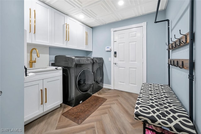 laundry area featuring cabinets, light parquet flooring, separate washer and dryer, and sink