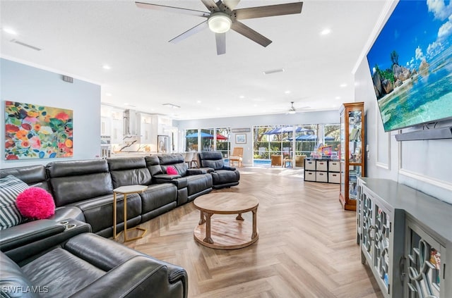 living room with light parquet floors, ceiling fan, and ornamental molding