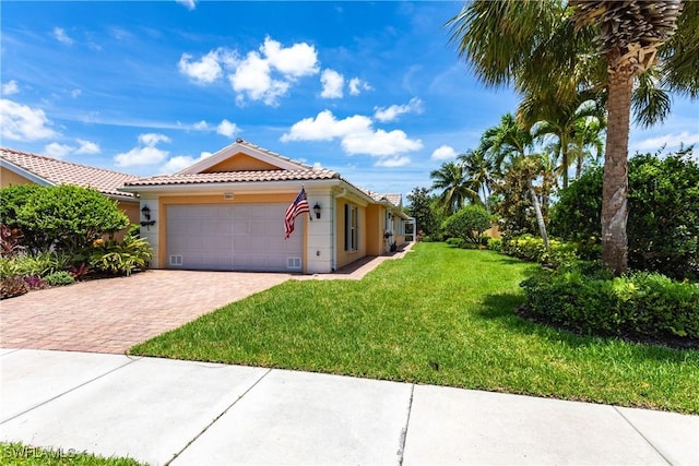 view of front facade featuring a garage, a tiled roof, decorative driveway, stucco siding, and a front yard