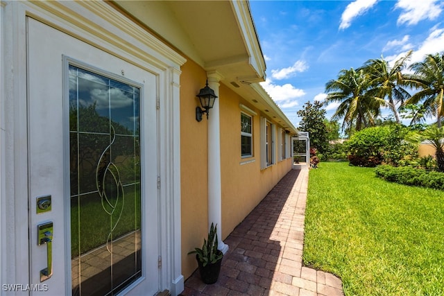 view of side of property featuring a lawn and stucco siding