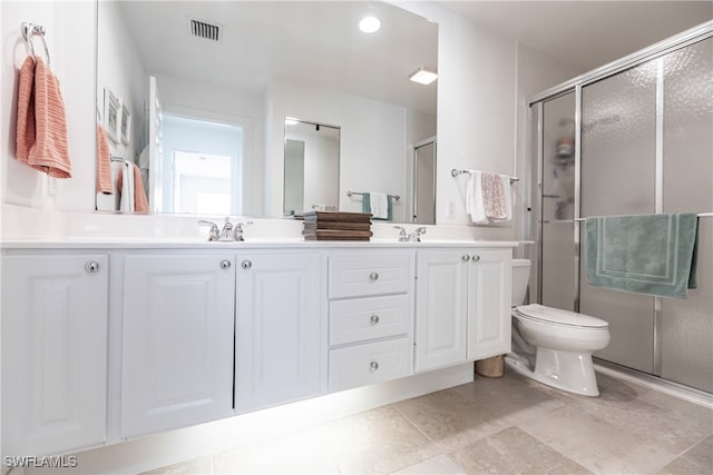 full bathroom featuring toilet, a sink, visible vents, double vanity, and a stall shower