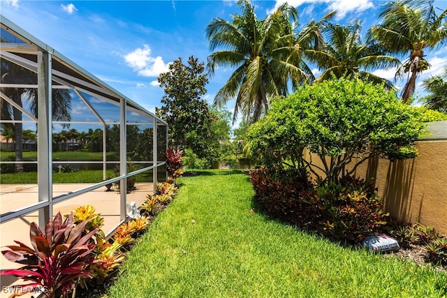 view of yard with a lanai and a water view