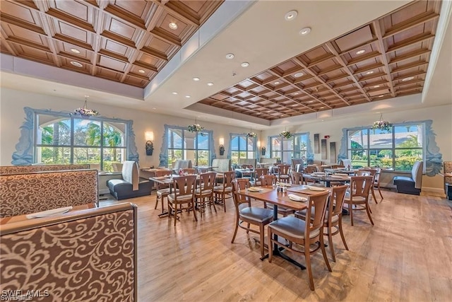 dining room featuring light wood-type flooring, coffered ceiling, a notable chandelier, and baseboards