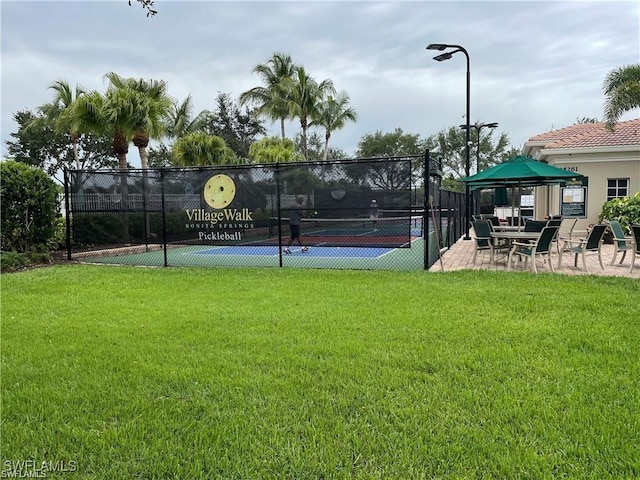 view of tennis court with a yard, a gazebo, and fence