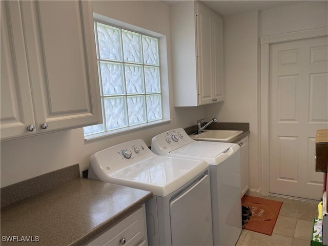 clothes washing area featuring washer and dryer, cabinet space, a sink, and light tile patterned floors