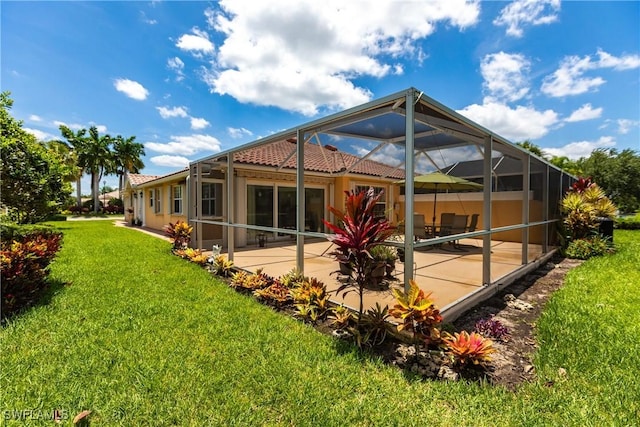 back of house with a lanai, a tile roof, a patio, and a lawn