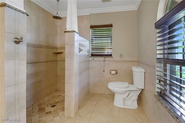 bathroom featuring a tile shower, crown molding, tile walls, and toilet