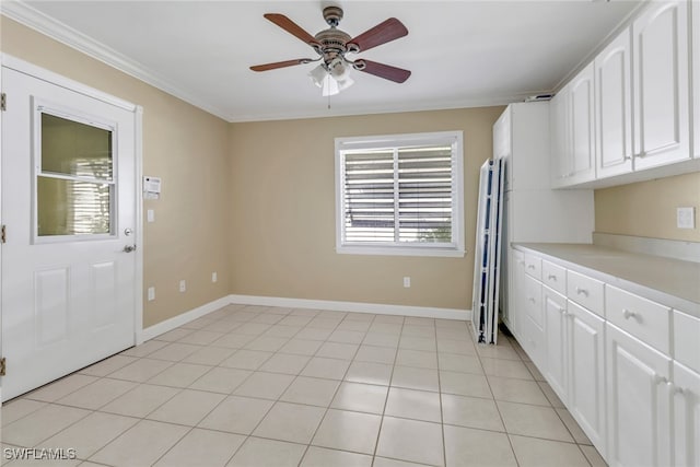 kitchen featuring crown molding, light tile patterned floors, a healthy amount of sunlight, and white cabinetry