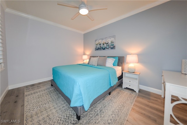 bedroom with crown molding, hardwood / wood-style flooring, and ceiling fan