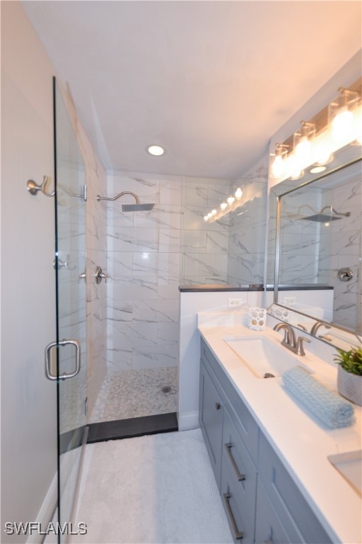 bathroom with a shower with door, vanity, and tile patterned flooring