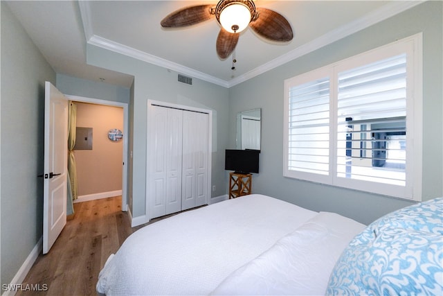 bedroom featuring ornamental molding, wood-type flooring, a closet, and ceiling fan