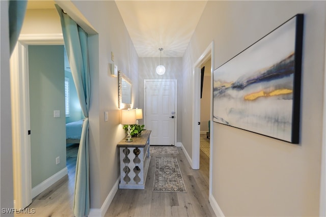 corridor with light hardwood / wood-style flooring