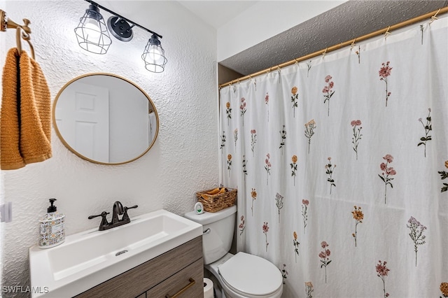 bathroom featuring curtained shower, vanity, and toilet