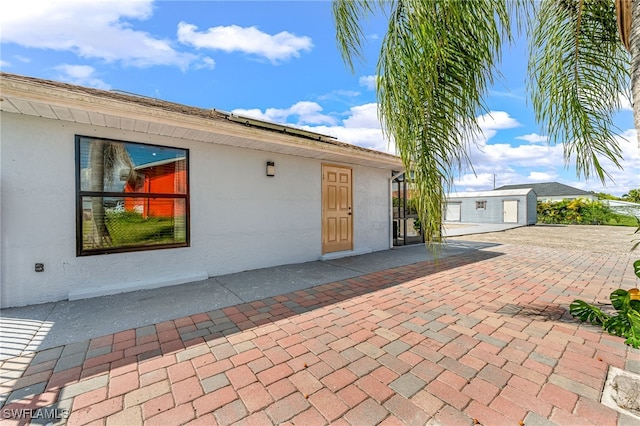 exterior space with a patio area and an outbuilding