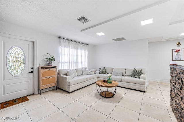 living room featuring light tile patterned flooring and a textured ceiling