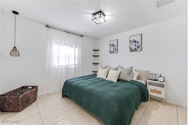 tiled bedroom featuring a textured ceiling