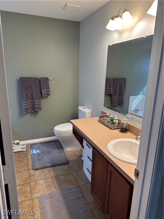 bathroom featuring tile patterned floors, vanity, and toilet