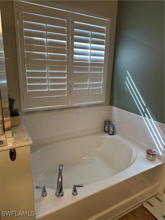 bathroom with tile patterned floors and a washtub