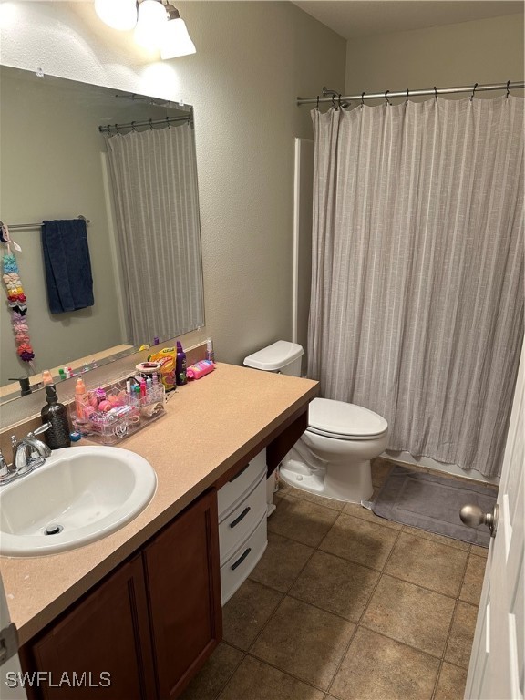 bathroom with tile patterned floors, vanity, and toilet