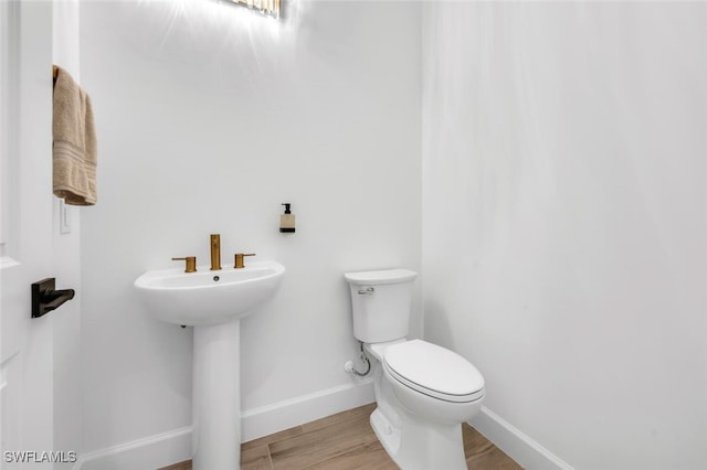 bathroom with toilet, hardwood / wood-style flooring, and sink