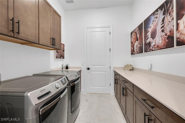 laundry area featuring washer and dryer and cabinets