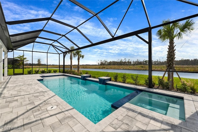 view of pool featuring a patio area, an in ground hot tub, a water view, and glass enclosure