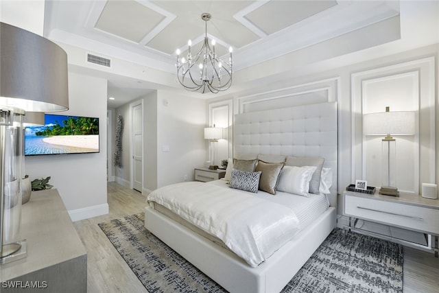 bedroom with light hardwood / wood-style flooring and an inviting chandelier