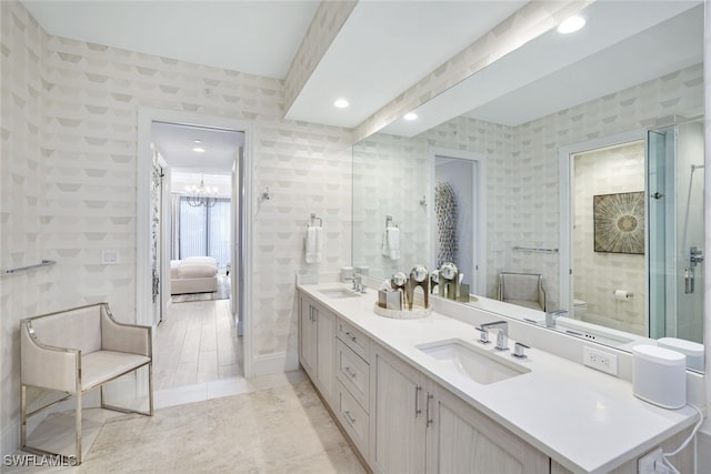 bathroom with an inviting chandelier, vanity, and toilet