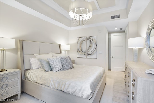 bedroom with light hardwood / wood-style flooring and an inviting chandelier