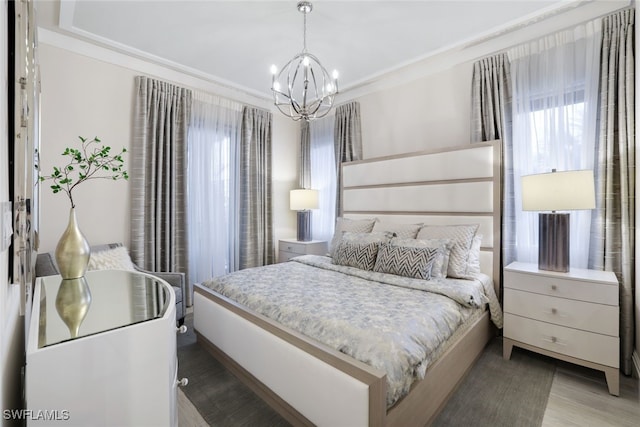 bedroom with crown molding, light hardwood / wood-style flooring, and a notable chandelier