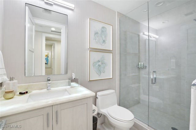 bathroom with an enclosed shower, vanity, and toilet