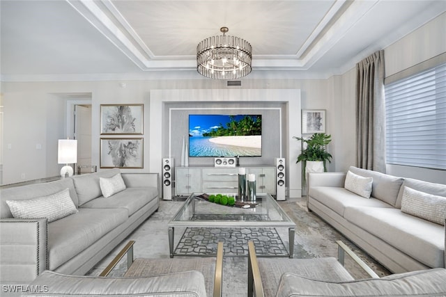 living room with a notable chandelier, crown molding, and a tray ceiling