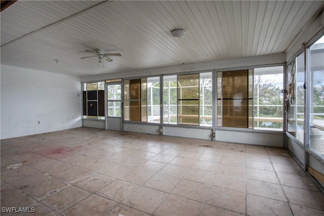 unfurnished sunroom featuring ceiling fan and a healthy amount of sunlight