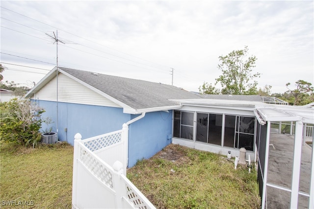 back of property with a lawn and a sunroom