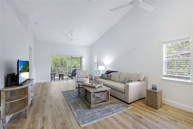 living room with light hardwood / wood-style floors and high vaulted ceiling