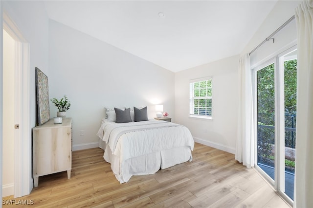 bedroom featuring access to exterior and light wood-type flooring