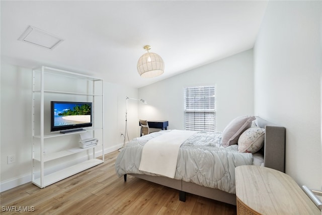 bedroom with lofted ceiling and light wood-type flooring