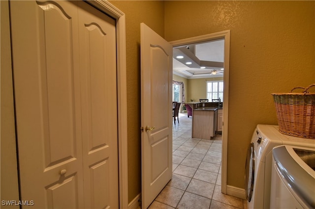 laundry room with ornamental molding, washer and dryer, and light tile patterned floors