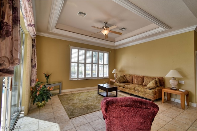 living room featuring ornamental molding, light tile patterned flooring, and a raised ceiling