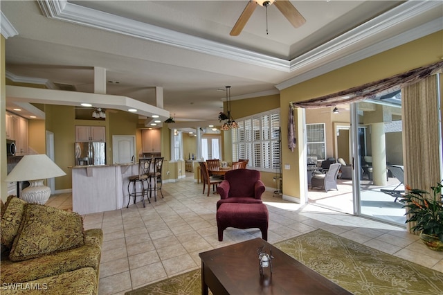 living room featuring ornamental molding, ceiling fan, light tile patterned floors, and a raised ceiling