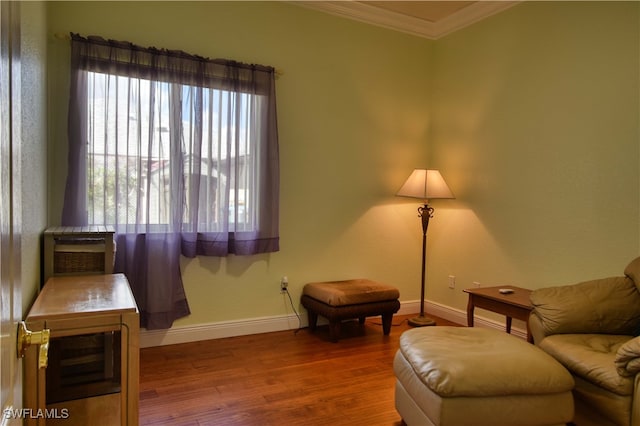 sitting room with ornamental molding and hardwood / wood-style floors