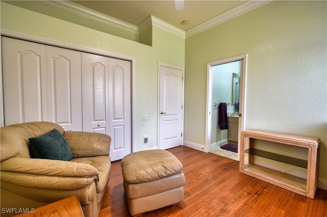 sitting room featuring wood-type flooring and ornamental molding