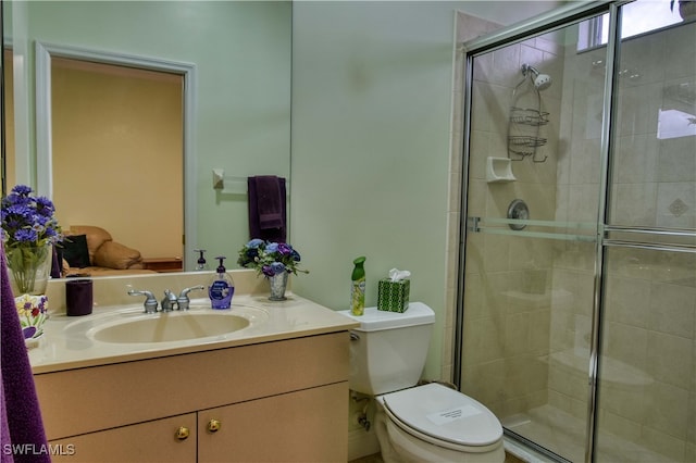 bathroom with walk in shower, vanity, and toilet