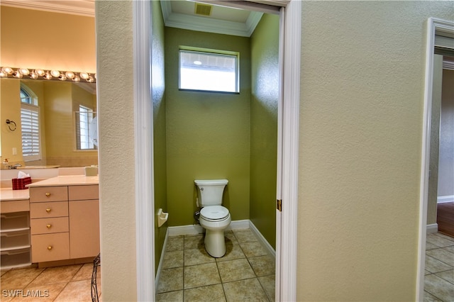 bathroom featuring tile patterned flooring, crown molding, vanity, and toilet