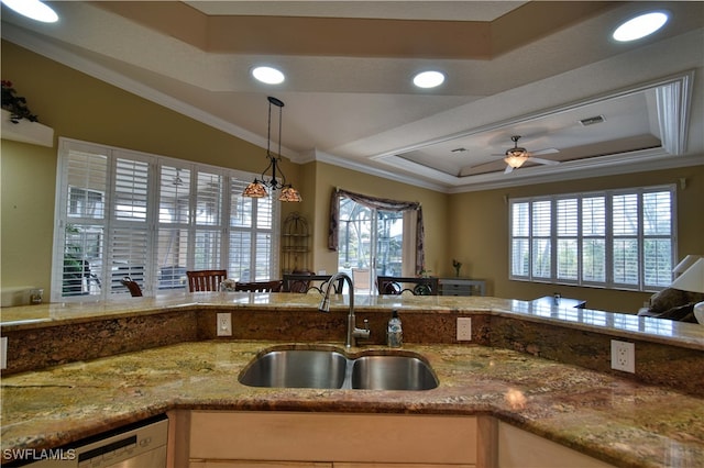 kitchen with ceiling fan, pendant lighting, a raised ceiling, ornamental molding, and sink