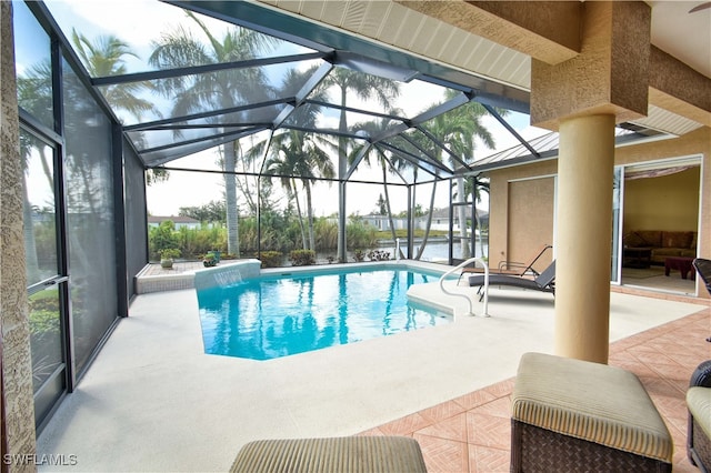 view of pool featuring glass enclosure and a patio area