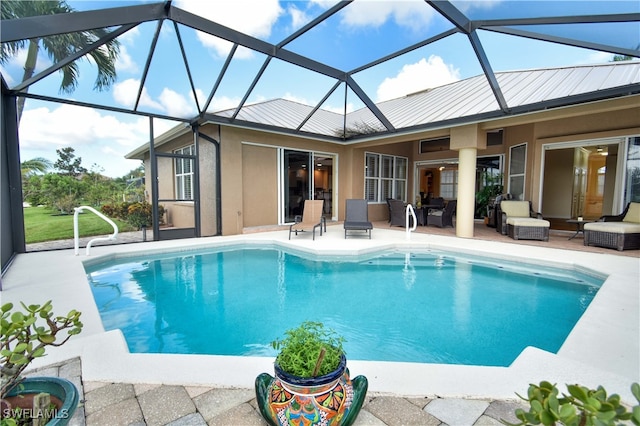 view of pool with glass enclosure and a patio area