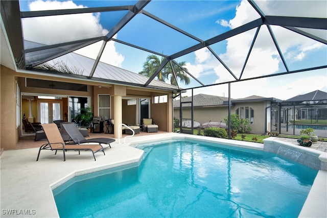 view of pool with french doors, glass enclosure, a patio area, and pool water feature